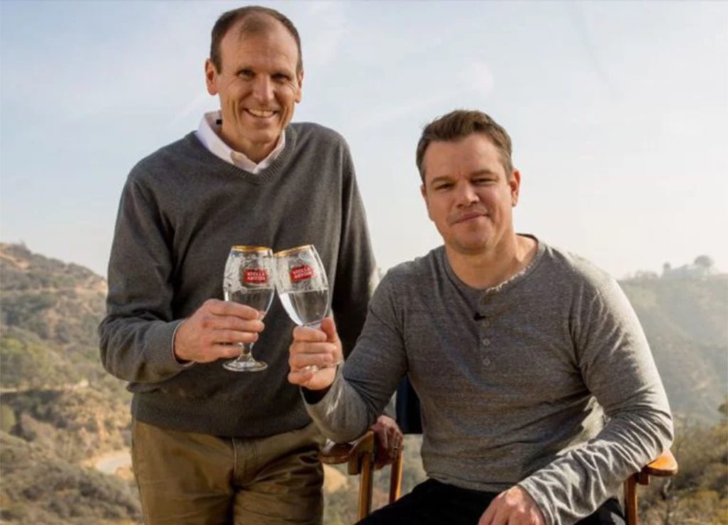 Gary White and Matt Damon holding Stella Artois chalices